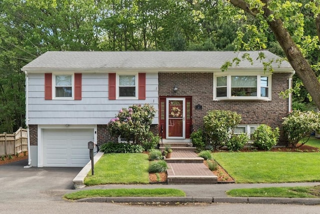 87 Lockwood Rd, Lynn, MA 01904 - split foyer home featuring driveway, brick siding, and an attached garage