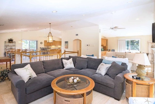 living room with arched walkways, a healthy amount of sunlight, lofted ceiling, and recessed lighting