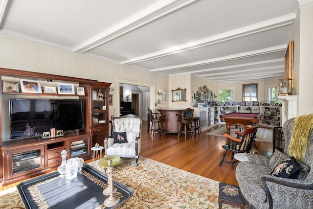 living room with a fireplace, beam ceiling, and hardwood / wood-style floors