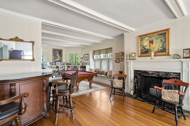 dining space featuring a fireplace, beamed ceiling, light hardwood / wood-style flooring, pool table, and ornamental molding