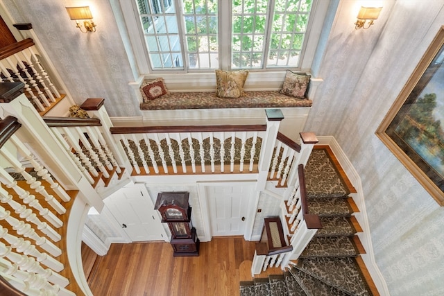 stairs with a high ceiling and hardwood / wood-style flooring