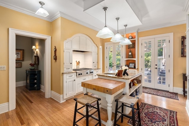 dining area featuring french doors, light wood-type flooring, and a healthy amount of sunlight