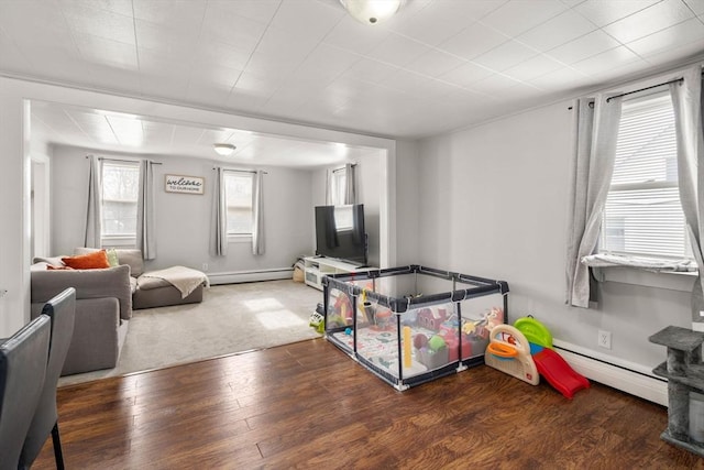 rec room with baseboards, baseboard heating, and dark wood-style flooring