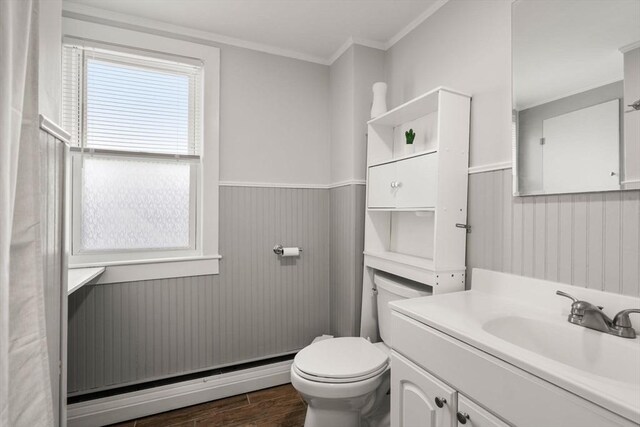 bathroom with a wainscoted wall, a baseboard radiator, ornamental molding, vanity, and wood finished floors