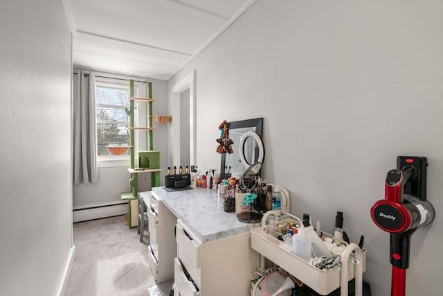 interior space featuring baseboards, light countertops, light carpet, and baseboard heating