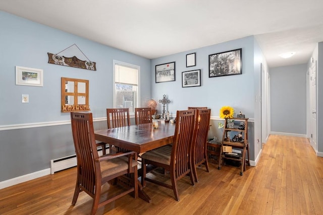 dining space featuring light wood-style flooring and baseboards