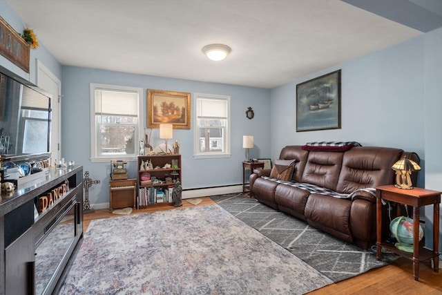 living room featuring a baseboard heating unit, a wealth of natural light, baseboards, and wood finished floors