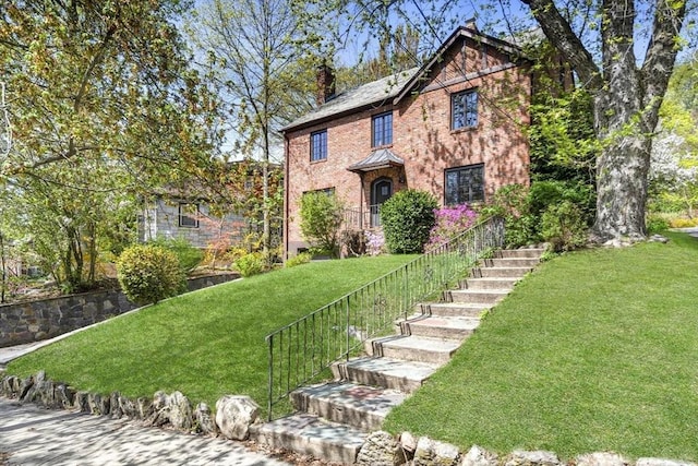 36 Blake Rd, Brookline, MA 02445 - view of front of house with a front lawn, brick siding, a chimney, and stairs