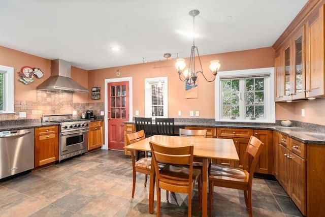 36 Blake Rd, Brookline, MA 02445 - kitchen featuring glass insert cabinets, brown cabinets, wall chimney range hood, stainless steel appliances, and tasteful backsplash