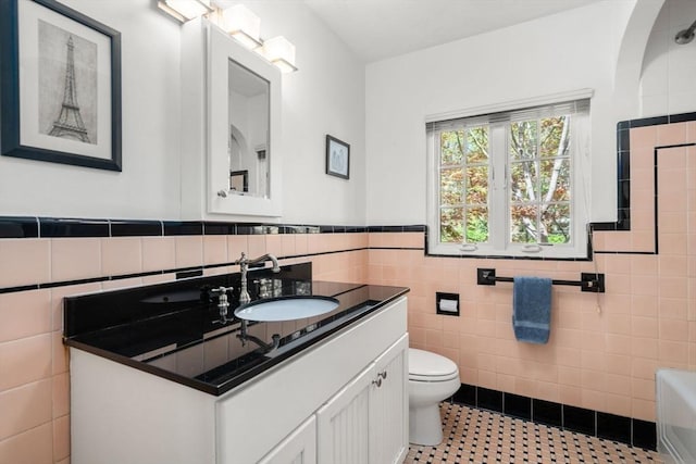 36 Blake Rd, Brookline, MA 02445 - bathroom featuring toilet, tile patterned floors, tile walls, wainscoting, and vanity