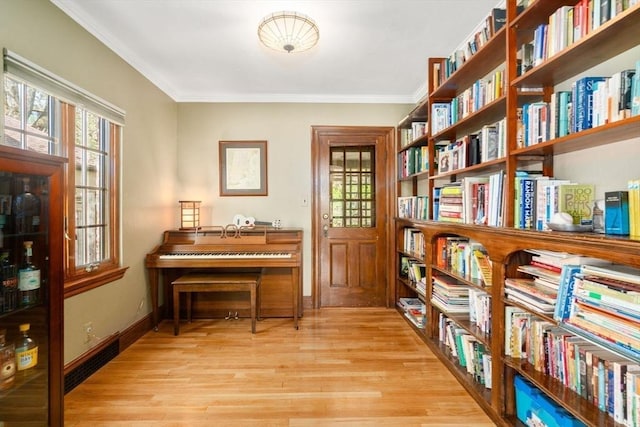36 Blake Rd, Brookline, MA 02445 - sitting room with baseboards, ornamental molding, bookshelves, and light wood-style flooring