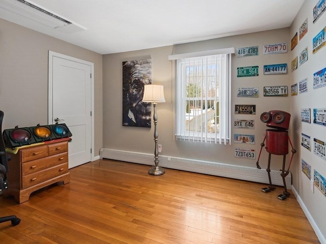 misc room with light wood finished floors, a baseboard radiator, visible vents, and baseboards