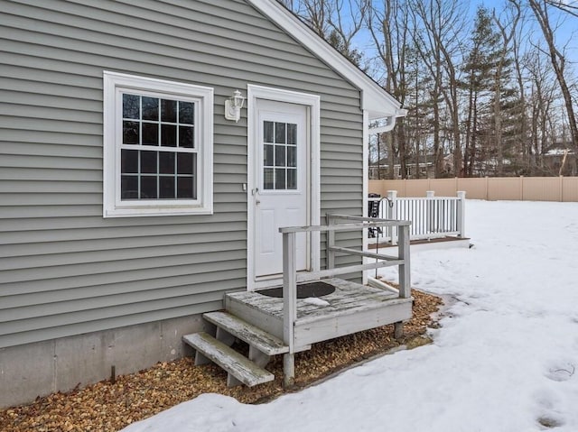 snow covered property entrance featuring fence