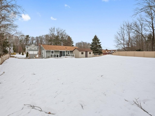 snow covered back of property featuring fence