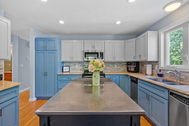 31 Monadnock Dr Unit 31, Westford, MA 01886 - kitchen featuring appliances with stainless steel finishes, a sink, blue cabinetry, backsplash, and recessed lighting