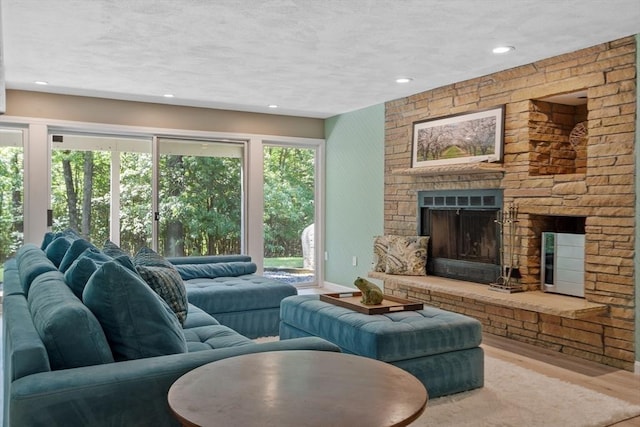 31 Monadnock Dr Unit 31, Westford, MA 01886 - living room featuring light wood finished floors, a fireplace, a textured ceiling, and recessed lighting