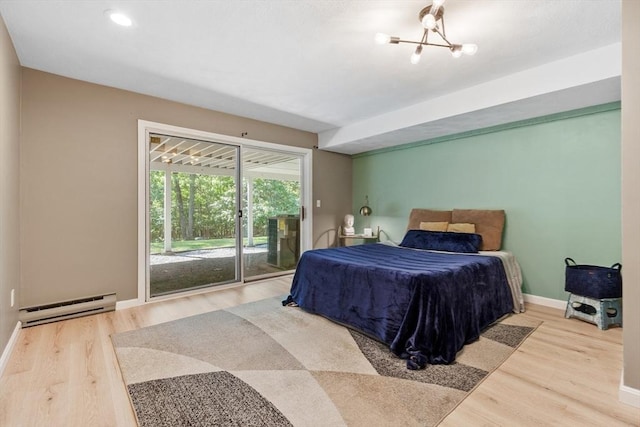 31 Monadnock Dr Unit 31, Westford, MA 01886 - bedroom featuring access to outside, baseboard heating, wood finished floors, baseboards, and a chandelier