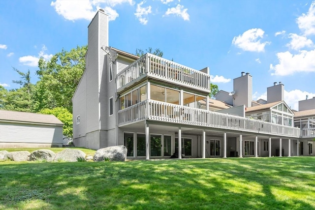 31 Monadnock Dr Unit 31, Westford, MA 01886 - back of property featuring a lawn, a chimney, a sunroom, a wooden deck, and a balcony