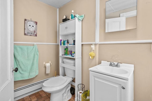 bathroom with vanity, toilet, and baseboard heating