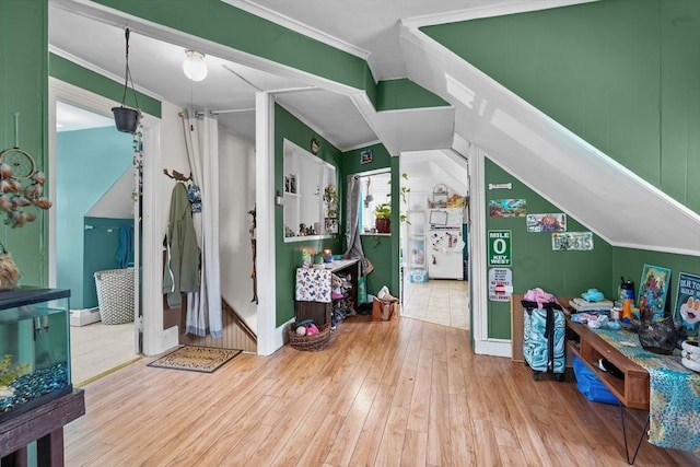 playroom featuring lofted ceiling, wood-type flooring, and ornamental molding