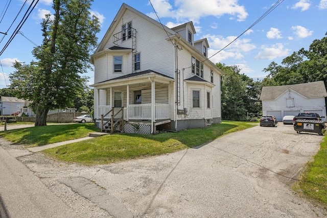 view of front of home featuring a front lawn, a porch, and a garage