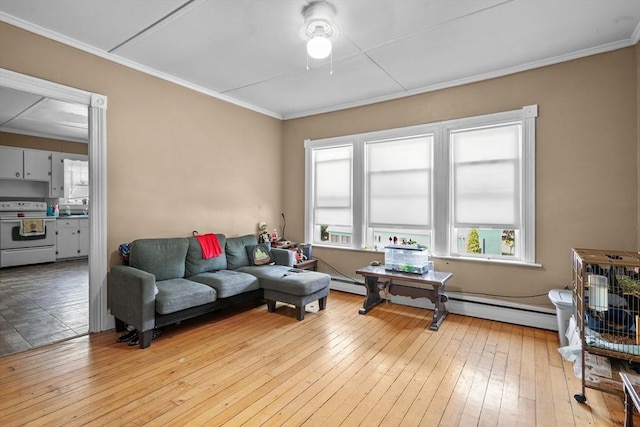 living room featuring crown molding, light wood-type flooring, sink, and baseboard heating