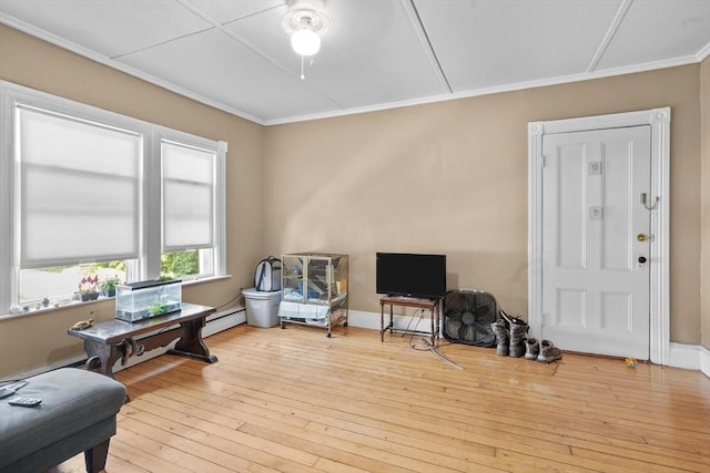 living area featuring crown molding, light hardwood / wood-style floors, and a baseboard radiator