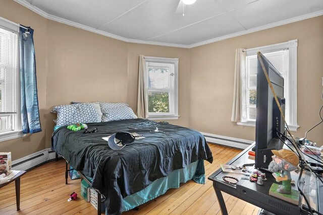 bedroom with a baseboard radiator, ceiling fan, and hardwood / wood-style flooring