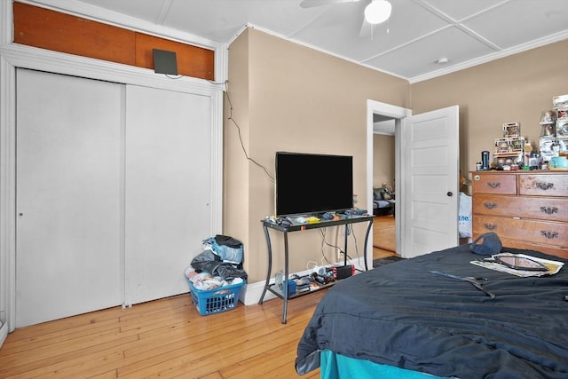 bedroom with ceiling fan, a closet, and wood-type flooring