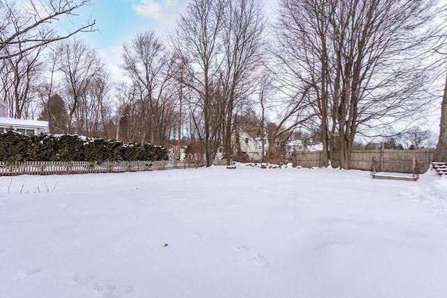 yard covered in snow featuring fence