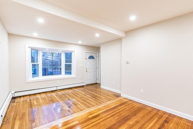 unfurnished room featuring hardwood / wood-style floors and a baseboard radiator