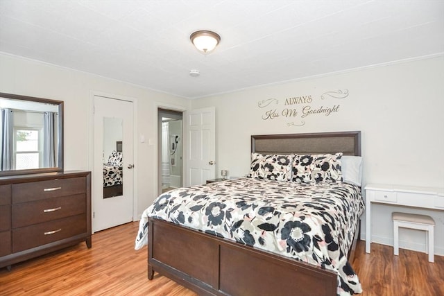 bedroom featuring crown molding and wood finished floors