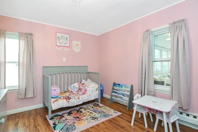 bedroom with crown molding, baseboards, and wood finished floors