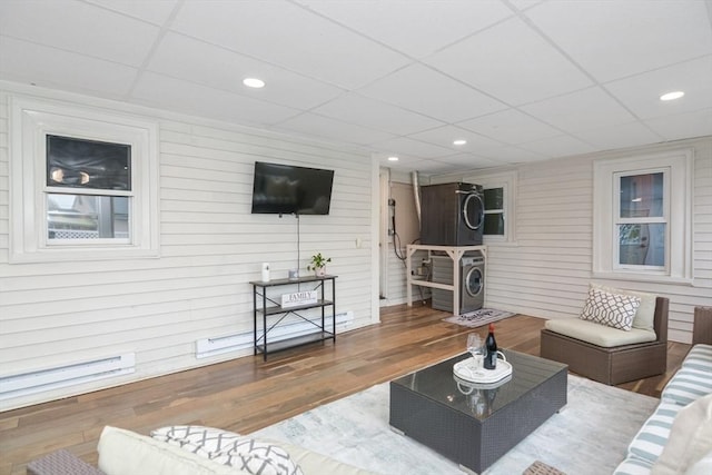 living room with wood finished floors, a drop ceiling, wooden walls, recessed lighting, and a baseboard radiator