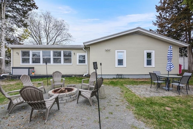 rear view of house with a patio and a fire pit