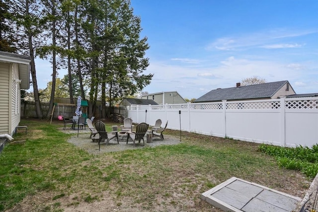 view of yard featuring a fenced backyard and a fire pit