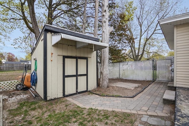 view of shed with fence and a gate