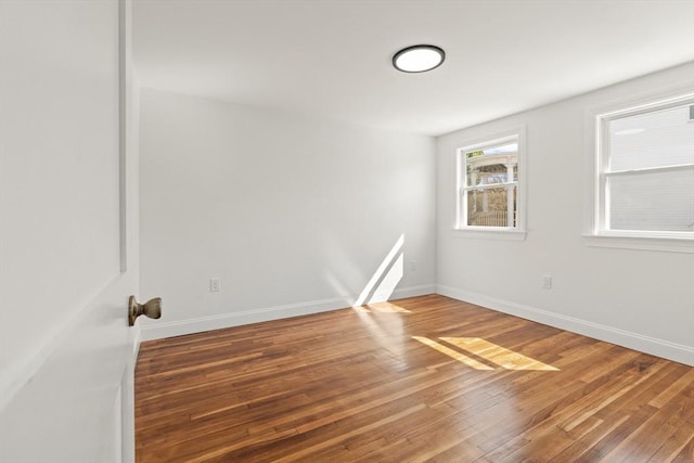 empty room with wood finished floors and baseboards