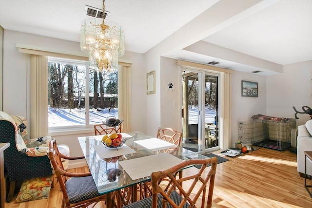 dining room with an inviting chandelier and light hardwood / wood-style flooring