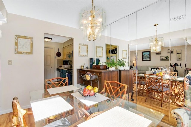 dining room with hardwood / wood-style flooring and an inviting chandelier