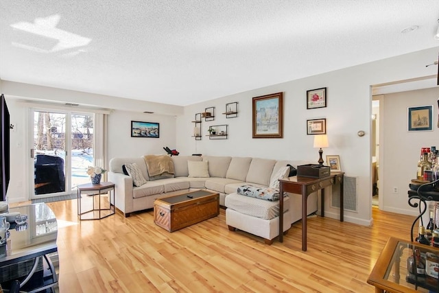 living room with light hardwood / wood-style flooring and a textured ceiling