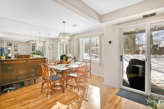 dining space featuring a notable chandelier and light hardwood / wood-style flooring