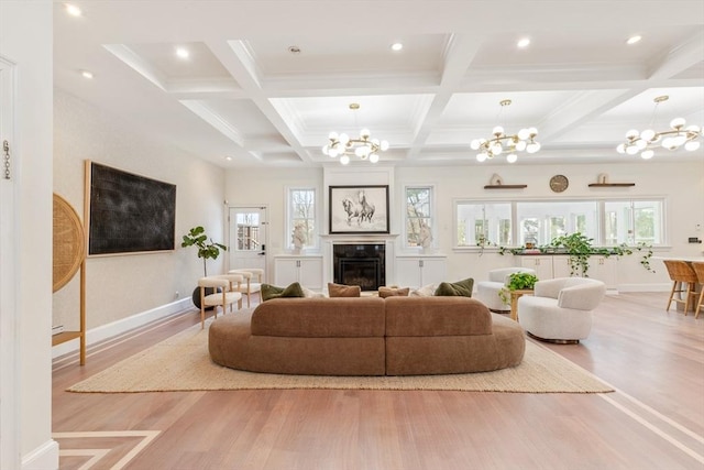 living room featuring a healthy amount of sunlight, a chandelier, and light wood-type flooring