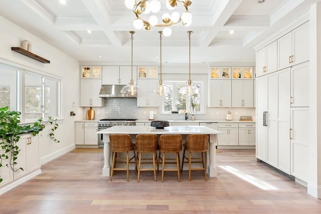 kitchen featuring a kitchen island, decorative light fixtures, white cabinetry, backsplash, and high end stainless steel range oven