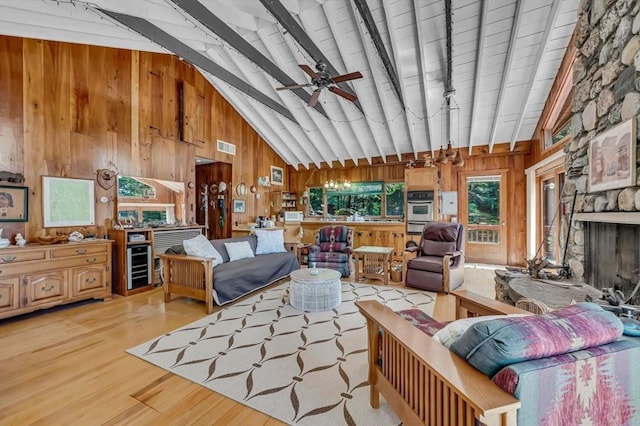 32 Pond Hill Rd, Goshen, MA 01032 - living room featuring wooden walls, beam ceiling, light wood-type flooring, wine cooler, and high vaulted ceiling