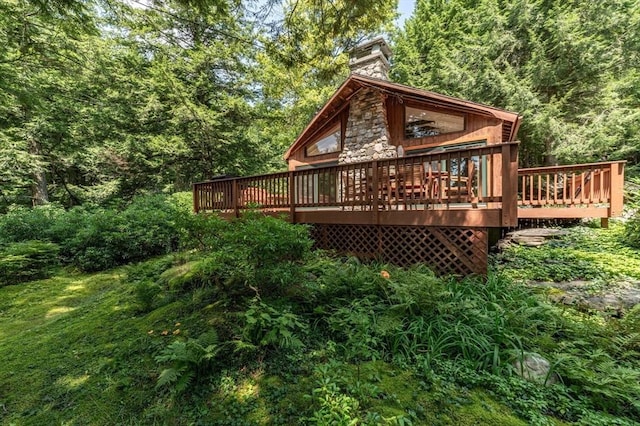 32 Pond Hill Rd, Goshen, MA 01032 - back of property featuring a wooden deck, stone siding, a chimney, and a forest view