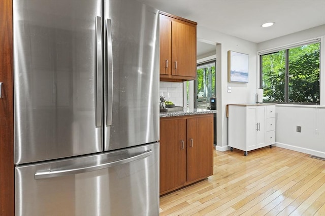 147 Butternut Holw Unit 147, Acton, MA 01718 - kitchen with freestanding refrigerator, brown cabinetry, light wood finished floors, tasteful backsplash, and baseboards