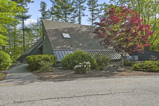 147 Butternut Holw Unit 147, Acton, MA 01718 - view of side of property with a standing seam roof, metal roof, and roof with shingles