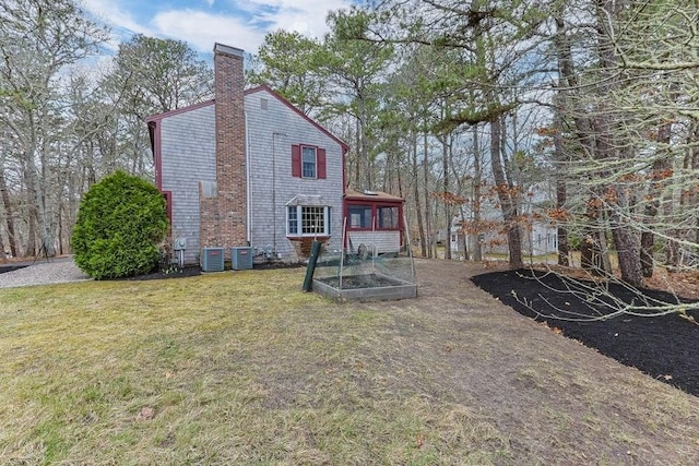 130 Surrey Ln, Brewster, MA 02631 - exterior space with a vegetable garden, a sunroom, and central air condition unit