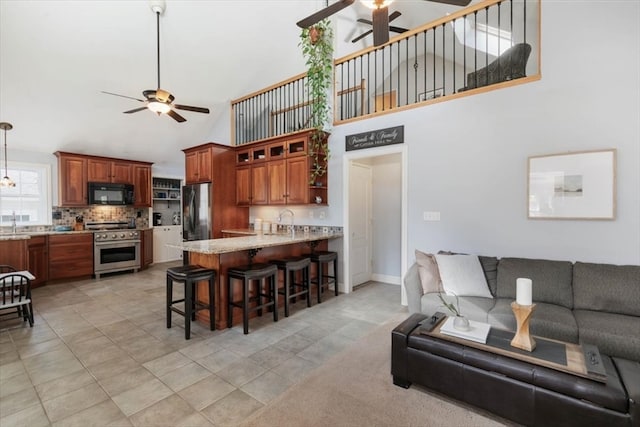 living room featuring a towering ceiling, ceiling fan, and light tile patterned flooring